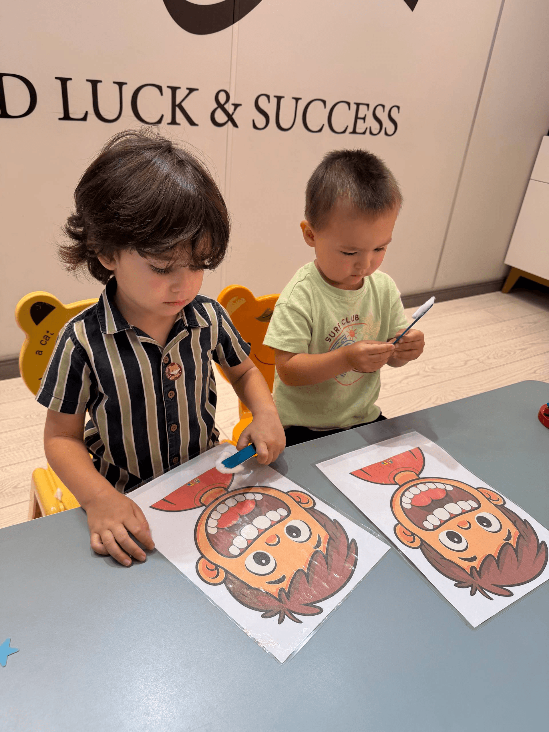 Two boys painting craft templates at a table at Little Britain Daycare