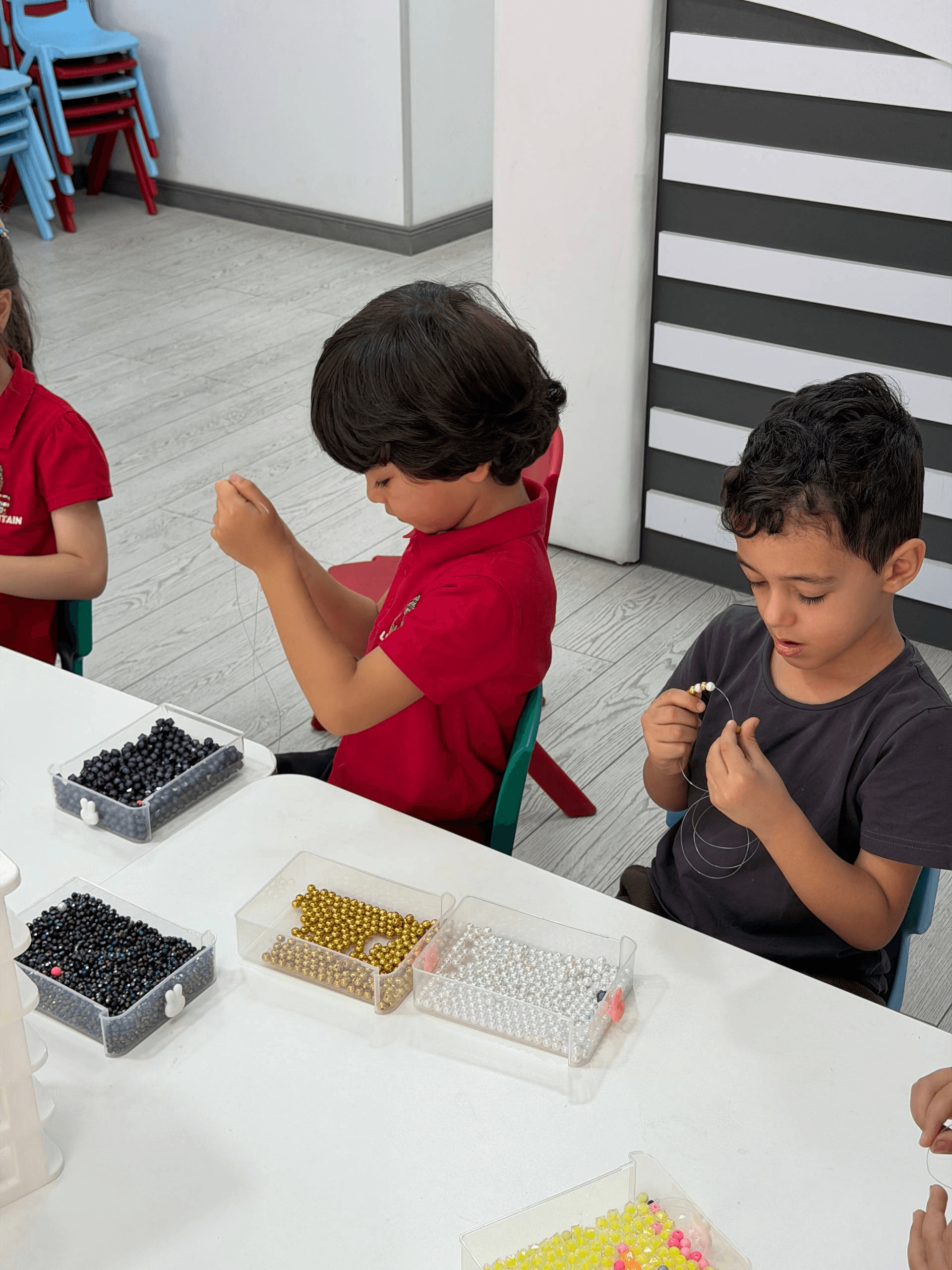 Two boys threading beads onto string at Little Britain Daycare