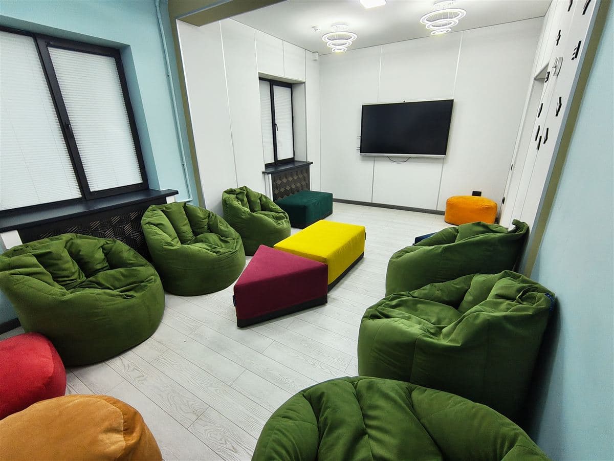 Cosy lounge with bean bag seating and TV for movie afternoons at Little Britain Daycare